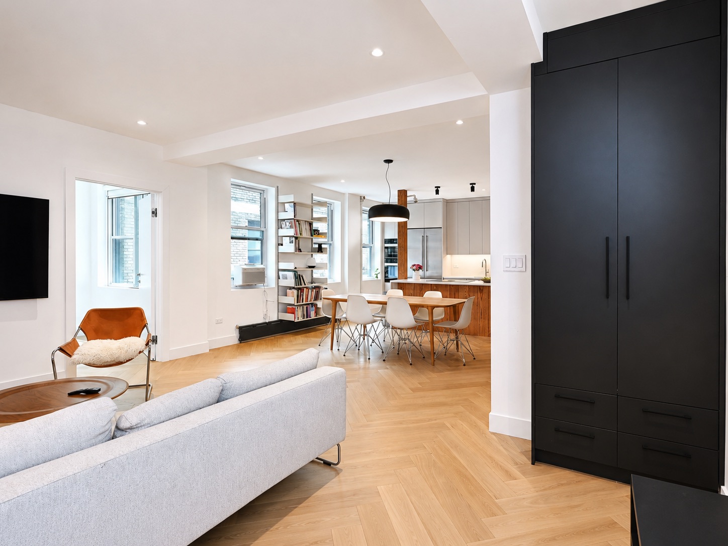 Open living and dining room with white oak herringbone floors